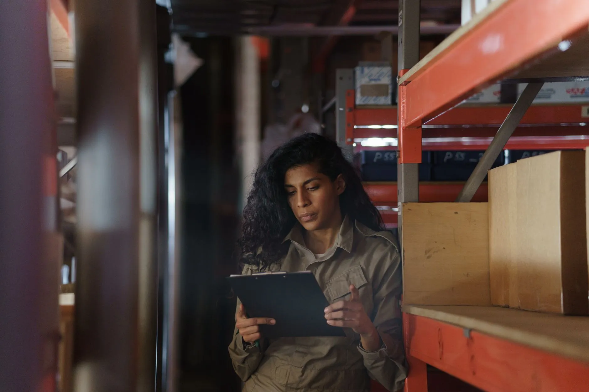 Distributor employee checking inventory in a warehouse aisle