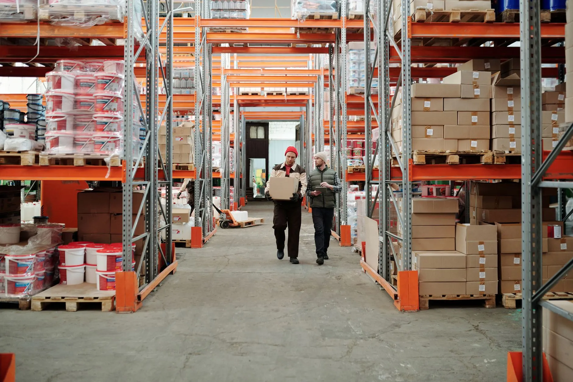 Distribution warehouse team processing orders among stocked shelves